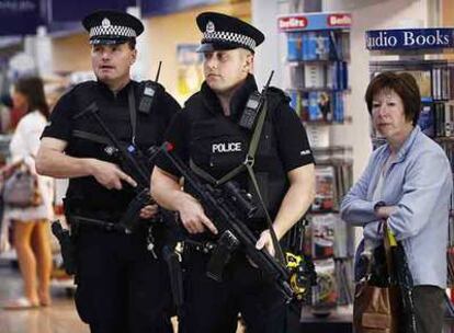 Policías armados vigilan la terminal de pasajeros del aeropuerto de Glasgow.