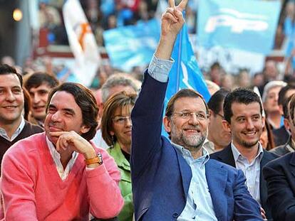 Rajoy saluda con la señal de la victoria junto a Aznar en el mitin de León.