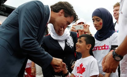 El primer ministro de Canadá, Justin Trudeau, con un niño refugiado sirio en 2016.