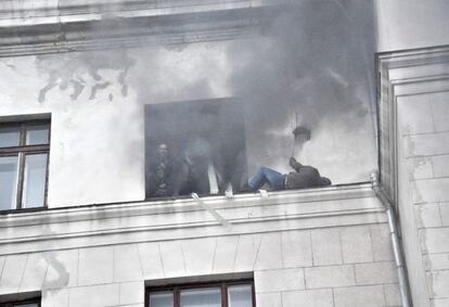Manifestantes pro-Rusos tratan de Escapar del edificio en llamas.