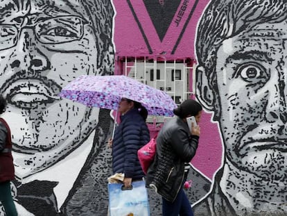 Transeúntes observan un mural del asesinado humorista Jaime Garzón, en Bogotá (Colombia).