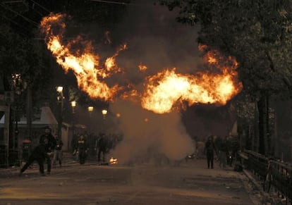 Una llamarada rodea a varios manifestantes durante las protestas en Atenas.