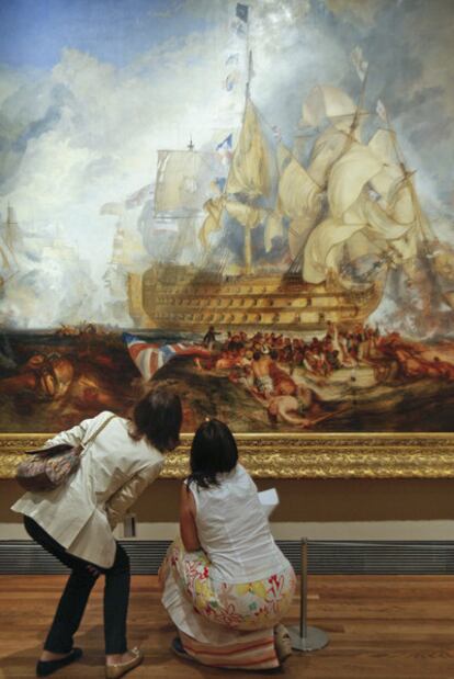 Dos visitantes de <i>Turner y los maestros</i>, en el Prado ante<i> La batalla de Trafalgar </i>del pintor inglés.