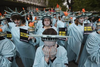 Activistas de Amnistia Internacional, con trajes de la Estatua de la Libertad, protestan frente a la Embajada de EE UU en Londres (Reino Unido), al cumplirse los primeros 100 días en el gobierno del presidente estadounidense, Donald Trump, para resaltar las supuestas violaciones de los derechos humanos cometidos durante su mandato.