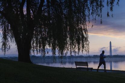 Un corredor de madrugada se recorta contra la neblina de la mañana a lo largo del río Potomac, en Washington.