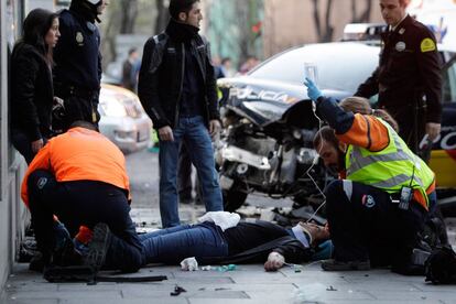 Una mujer es atendida por el Samur tras el choque entre un turismo y un coche patrulla de la policía en el que han resultado heridas cinco persona. El vehículo policial participaba en el dispositivo de seguridad por la huelga general.