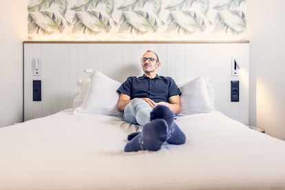El escritor Isaac Rosa, en la cama de su habitación en un hotel céntrico de Madrid, el 4 de septiembre de 2025. 