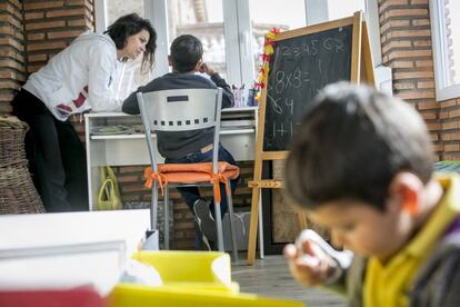 Una madre ayuda a sus hijos confinados en casa a hacer las tareas durante una cuarentena escolar en Madrid.