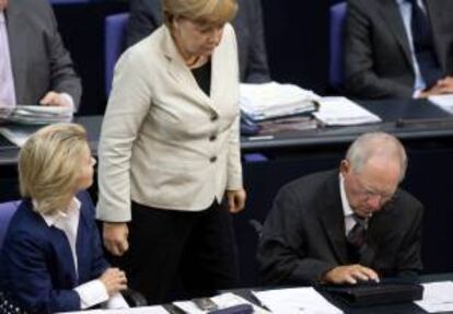 La canciller alemana, Angela Merkel (centro), conversa con la ministra alemana de trabajo, Ursula von der Leyen (izda), y el ministro alemán de Finanzas, Wolfgang Schäuble (dcha), hoy en el Bundestag en Berlín (Alemania).