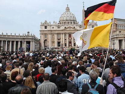 Las banderas de Alemania y del Vaticano ondean sobre las cabezas de cientos de peregrinos que asisten a la misa de Benedicto XVI en la plaza de San Pedro.