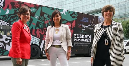 De izquierda a derecha, Mertxe Garmendia, Itziar Epalza y Arantza Madariaga, este viernes en Bilbao ante el autobús de promoción turística. 