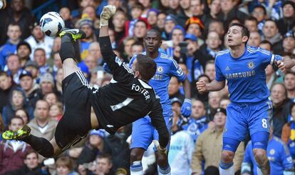 El portero del West Bromwich, Ben Foster, trata de rematar ante Lampard y Ramires.