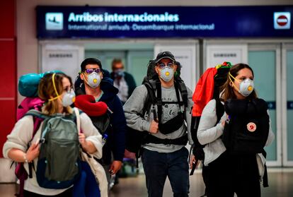 Pasajeros con mascarillas a su llegada al aeropuerto internacional de Ezeiza, en Buenos Aires