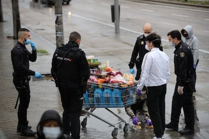 Vários agentes da Policial Nacional abordam duas pessoas que faziam compras em um supermercado de Madri.