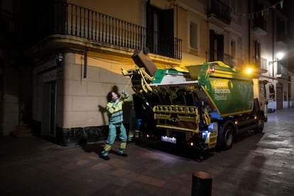 Un trabajador de la limpieza recoge la basura orgánica con el sistema puerta a puerta en la calle Major de Sarrià de Barcelona.