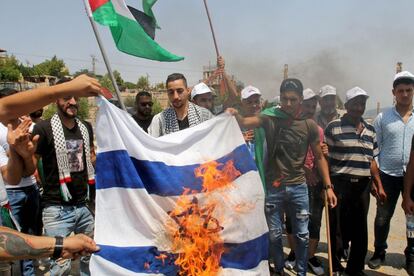 Libaneses queman una bandera israelí mientras izan una palestina durante la protesta en los Jardines de Irán, en la frontera israelí-libanesa.