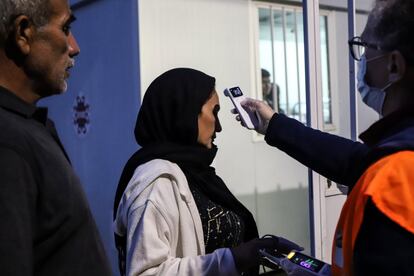 Una enfermera de la ONG Rainbow4Africa comprueba la temperatura de una mujer afgana en el refugio Fraternità Massi de Oulx. Cada día, las sanitarias realizan exámenes generales de las personas acogidas como medida preventiva contra la covid-19.