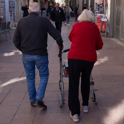 Dos ancianos caminan por una calle de Sevilla.