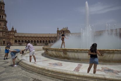 Varios jóvenes se refrescan en la plaza de España en Sevilla. De momento este sábado ocho comunidades han activado el aviso meteorológico por calor, cuatro de ellas en nivel naranja, por riesgo importante, (Andalucía, Castilla-La Mancha, Extremadura y Madrid) y las otras cuatro en nivel amarillo (Aragón, Castilla y León, Cataluña y Comunidad valenciana).