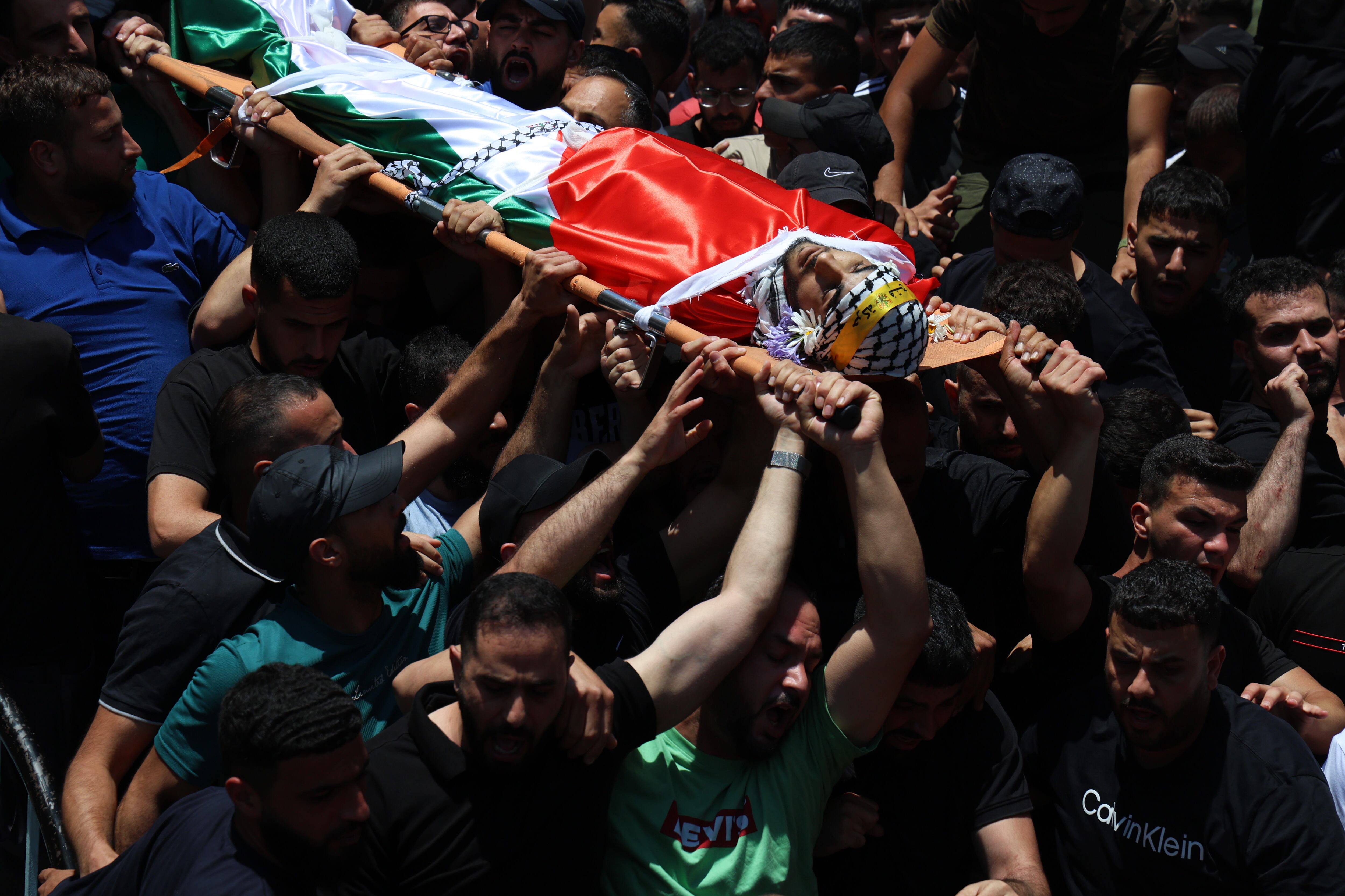 Varias personas portan este jueves el cuerpo de un palestino muerto por balazos de soldados israelíes en Kafar Malek (Cisjordania) durante un ataque de colonos judíos a esta localidad.
