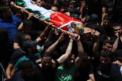 Varias personas portan este jueves el cuerpo de un palestino muerto por balazos de soldados israelíes en Kafar Malek (Cisjordania) durante un ataque de colonos judíos a esta localidad.
