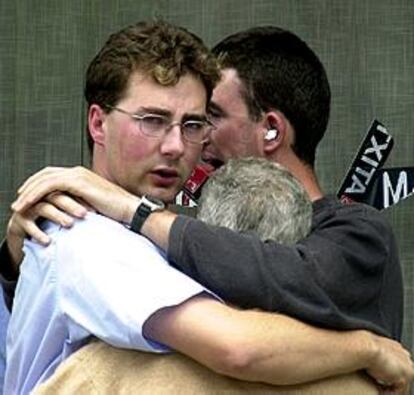 Dos de los hijos del concejal se abrazan a un familiar tras conocer su muerte.