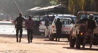 Na imagem, um homem é escoltado por forças de segurança depois de sair do hotel em Bamako.