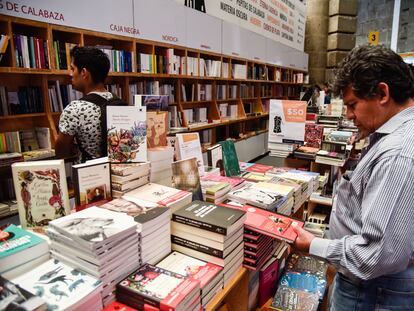 Un hombre lee la contraportada de un libro, en la FIL del Palacio de Minería, en febrero de 2020.