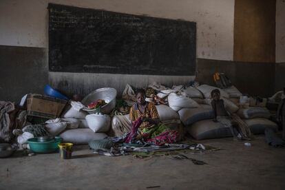 Una mujer y una niña en una de las aulas del Instituto de Barsalogho, en Burkina Faso, usada como dormitorio y almacén por los desplazados del conflicto que proceden del norte.