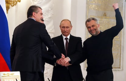 Russia's President Vladimir Putin (2nd R), Crimean Prime Minister Sergei Aksyonov (L), Crimean parliament speaker Vladimir Konstantinov (2nd L) and Alexei Chaly, Sevastopol's new de facto mayor (R), join hands after signing a treaty on the Ukrainian Black Sea peninsula becoming part of Russia in the Kremlin in Moscow on March 18, 2014.