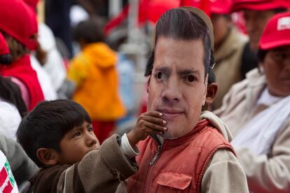 Un niño con una máscara de Peña Nieto en el cierre de su campaña presidencial en 2012.