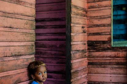 El nieto de un pescador del pueblo de Junco se apoya en las paredes de madera de su casa, que está siendo erosionada por el canal Urucurituba, en la desembocadura del río Amazonas, en el Estado de Amapá, en el norte de Brasil, en abril de 2022. Los habitantes de este pueblo se vieron inundados por la corriente del río. 