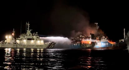 In this photo provided by the Philippine Coast Guard, a Philippine Coast Guard ship trains its hose as it tries to extinguish fire on the MV Lady Mary Joy at Basilan, southern Philippines early Thursday March 30, 2023.