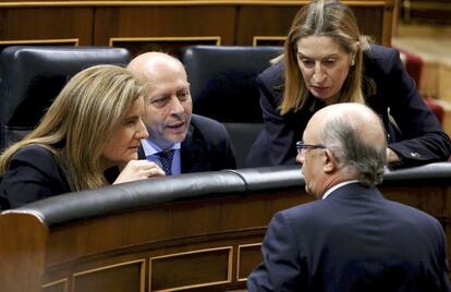 Fátima Báñez, ministra de de Empleo y Seguridad Social, José Ignacio Wert, responsable de la cartera de Educación, Cultura y Deporte y Ana Pastor, de Fomento, atienden a Cristóbal Montoro, ministro de Hacienda y Administraciones públicas (de espaldas) en el hemiciclo