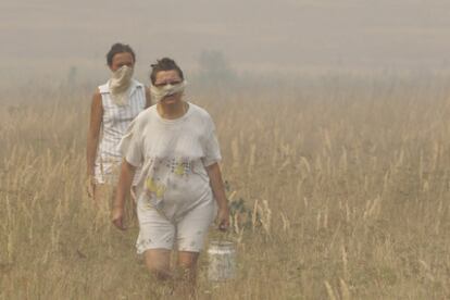 Dos mujeres se alejan de un incendio cerca de la localidad rusa de Polyaki-Maydan, 380 kilómetros al sureste de Moscú.