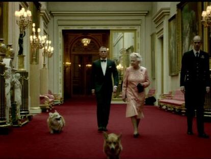 Isabel II y Daniel Craig camina por uno de los corredores del Palacio de Buckingham.