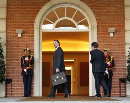 José Enrique Serrano, jefe de gabinete del expresidente del Gobierno, José Luis Rodríguez Zapatero, a compaña al presidente del Gobierno, Mariano Rajoy, a su llegada al Palacio de la Moncloa con su cartera, tras jurar su cargo ante el rey en la Zarzuela, el 21 de diciembre de 2011.