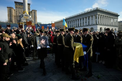 A serviceman carries a photo of Ukrainian officer Dmytro Kotsiubaylo during a commemoration ceremony in Independence Square in Kyiv, Ukraine, on March 10, 2023.