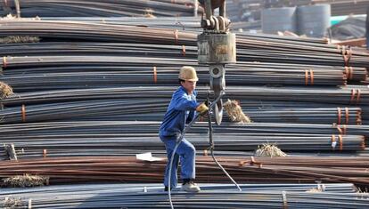 Obreros descargan barras de acero en un mercado mayorista de Shenyang, en la provincia china de Liaoning.