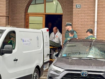 Agentes de la Guardia Civil y personal sanitario en la puerta del domicilio familiar de Pola de Laviana (Asturias) donde se ha producido el asesinato.