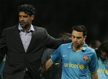 Frank Rijkaard y Xavi, después de la eliminación del Barcelona ante el Manchester United. A la derecha, Messi.