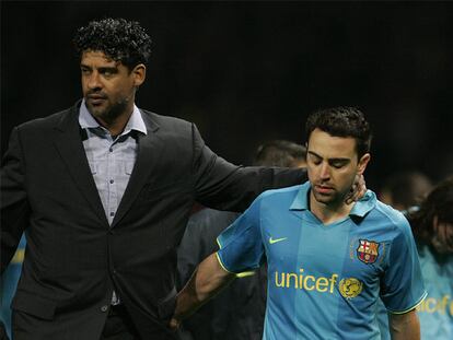 Frank Rijkaard y Xavi, después de la eliminación del Barcelona ante el Manchester United. A la derecha, Messi.