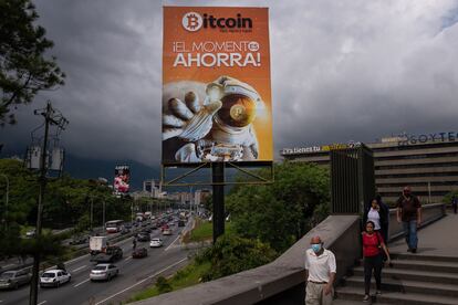 Ante esta transición, muchas de las odas al líder revolucionario venezolano que antes eran omnipresentes han desaparecido o están en proceso de desaparición. Ahora, las carreteras de la ciudad están llenas de vallas publicitarias que anuncian todo tipo de productos. En esta fotografía, una valla publicitaria de Bitcoin en la Avenida Galarraga, en Caracas, el 12 de agosto de 2022.