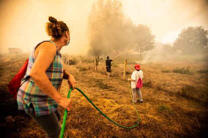 Vecinos de la localidad orensana de Cualedro intentan sofocar el incendio que asola su municipio.