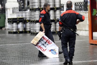 Dos <b><i>ertzainas</b></i> retiraban el pasado martes un cartel en apoyo de un preso etarra colocado en el recinto festivo de Bilbao.