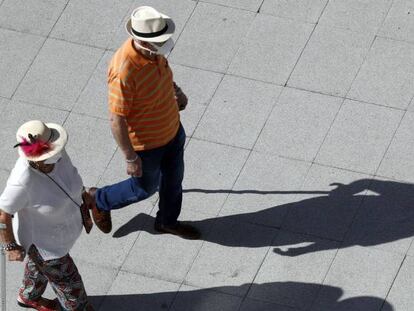 Un matrimonio jubilado protegido con mascarillas pasea en su franja horaria el domingo en Bilbao