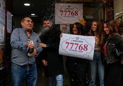 Empleados de la administración situada en la calle Jaume I, 1 de Paiporta (Valencia) celebran que han vendido parte del número 77768 correspondiente al cuarto premio.