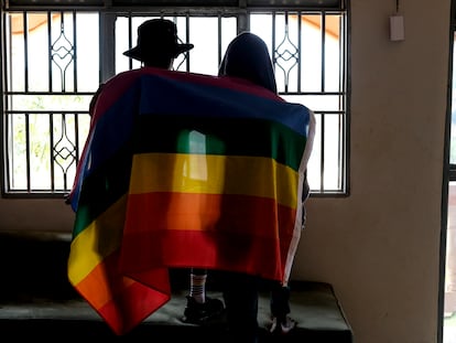 A Ugandan gay couple wraps themselves in an LGBTQI+ flag on March 25, 2023.