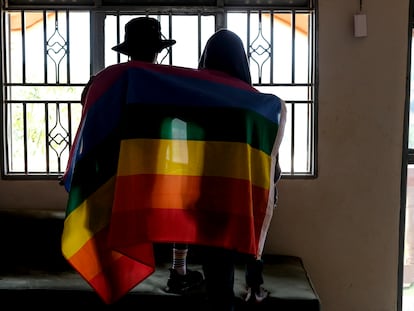 Una pareja gay de Uganda se cubre con una bandera LGTBI el 25 de marzo de 2023