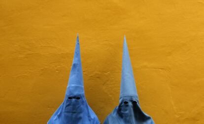 Penitentes de la hermandad de San Esteban posantes de participar en una procesión en la Semana Santa en Sevilla.